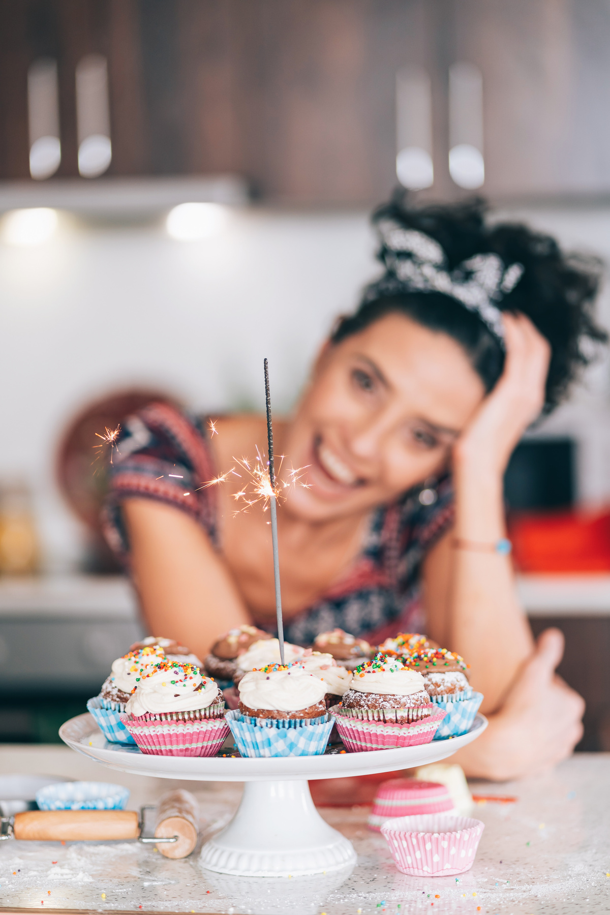 Confectioner holding birthday cupcakes